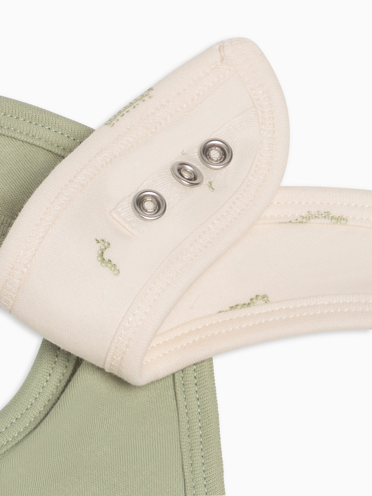 Close-up of adjustable nickel-free snaps on Mint and Caterpillar baby bibs.