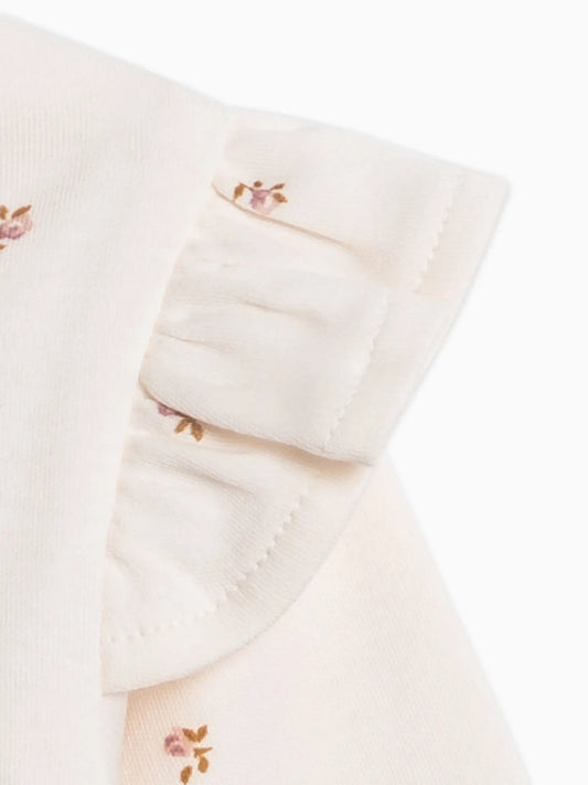 Close-up of the Hazel Cardigan's cream organic cotton fabric, delicate Etta floral print, and ruffled shoulder.