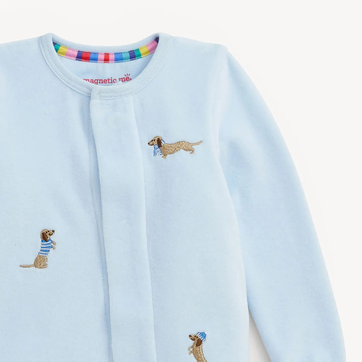 Close-up of embroidered dog details on the blue Magnetic Me velour footie.
