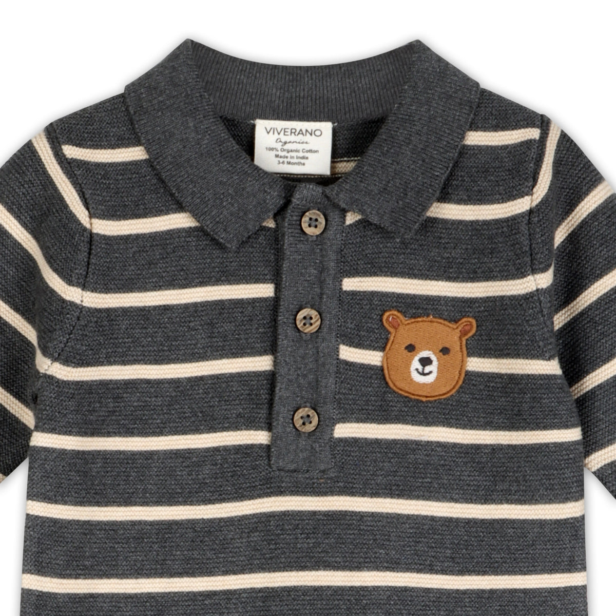 Close-up of the striped knit baby jumpsuit showing the contrast-trimmed collar, front buttons, and bear face chest detail.