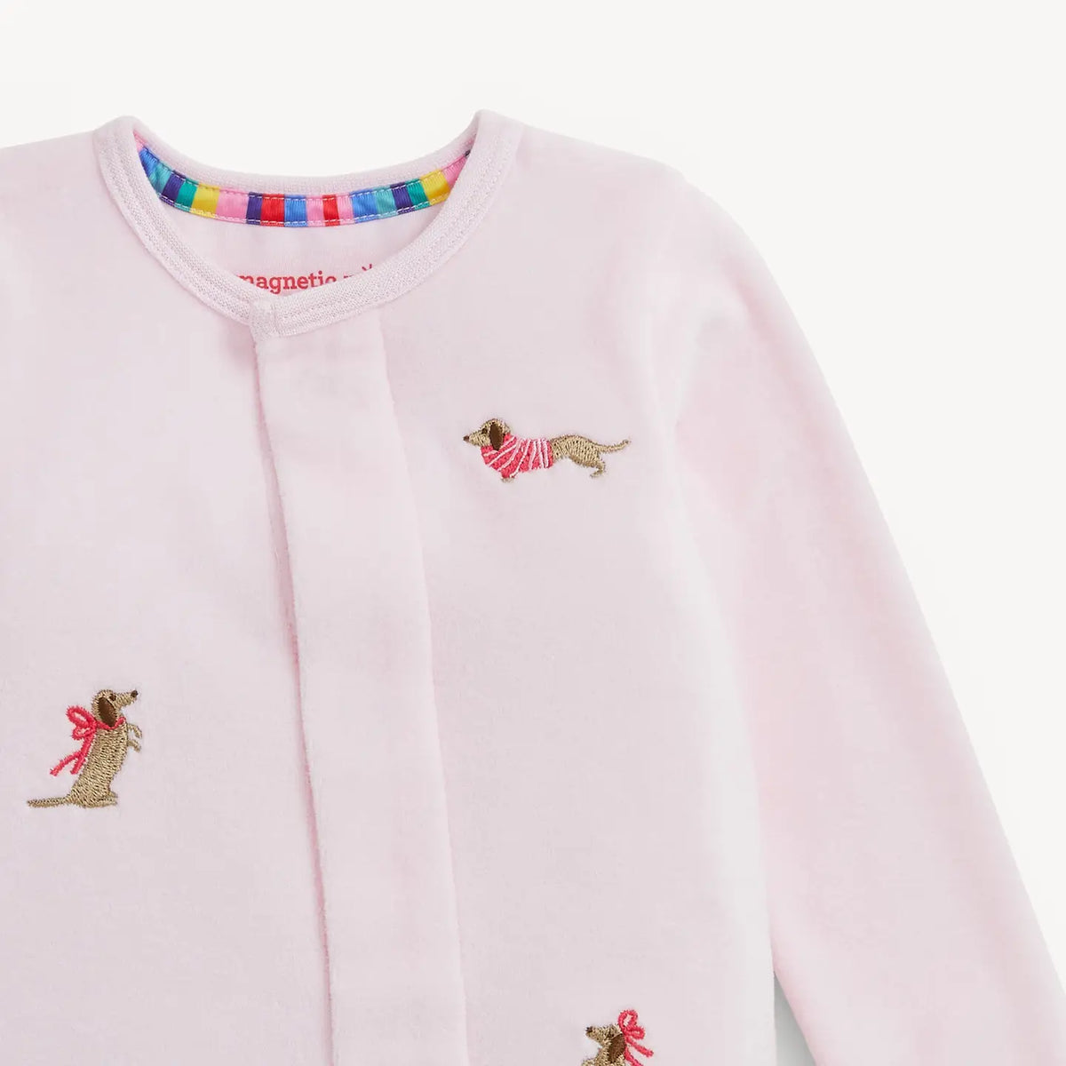 Close-up of the embroidered dog details on the pink Magnetic Me velour footie.