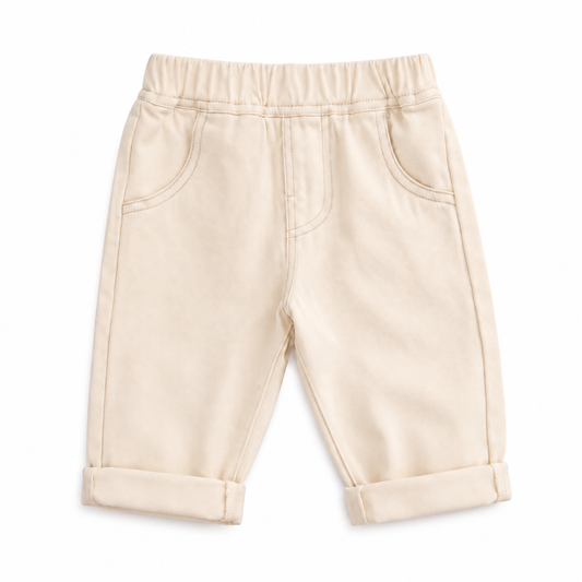 Ivory unisex toddler jeans with elastic waistband, front pockets, and rolled cuffs.
