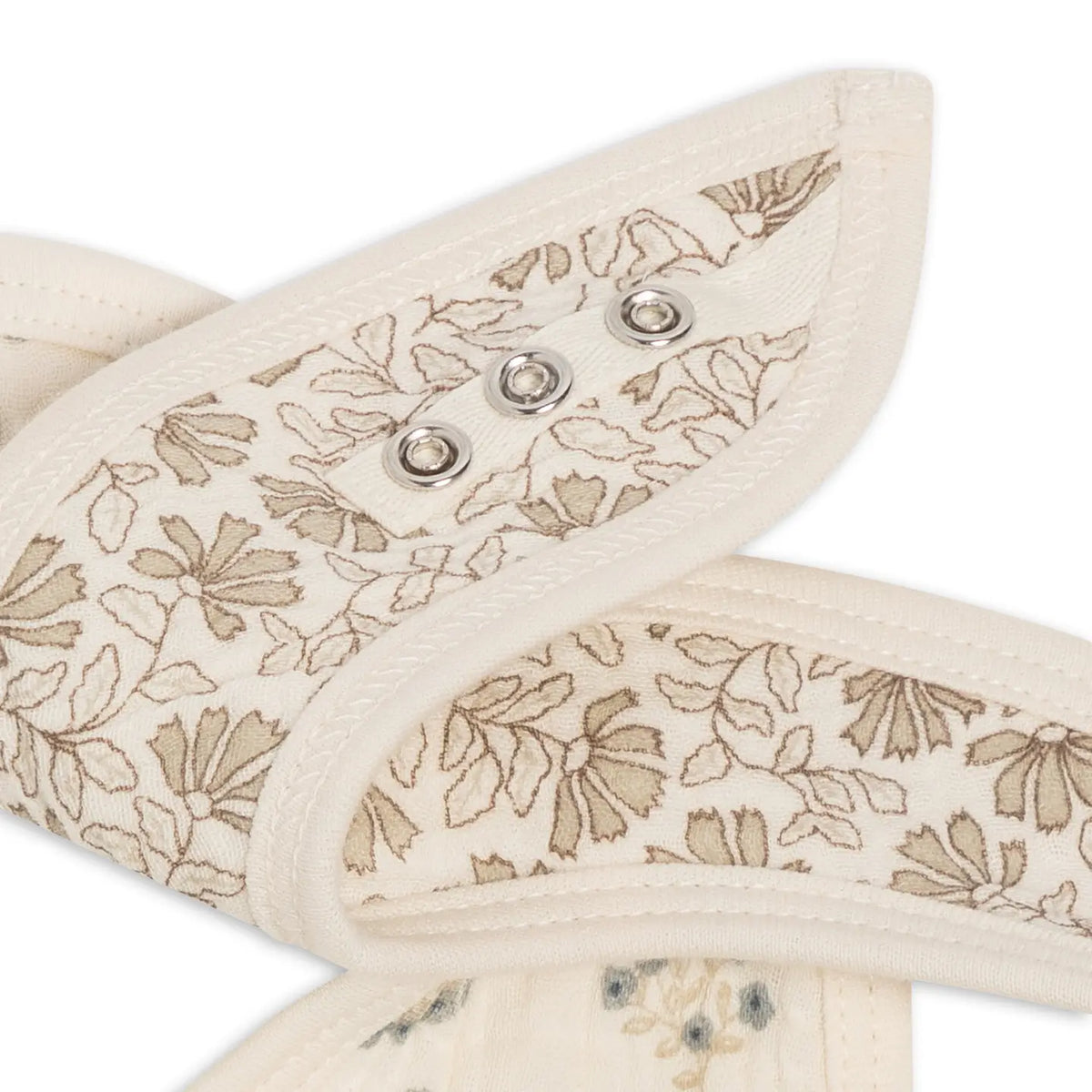 Close-up of adjustable snaps on Hayden and Laverne Floral muslin bibs.