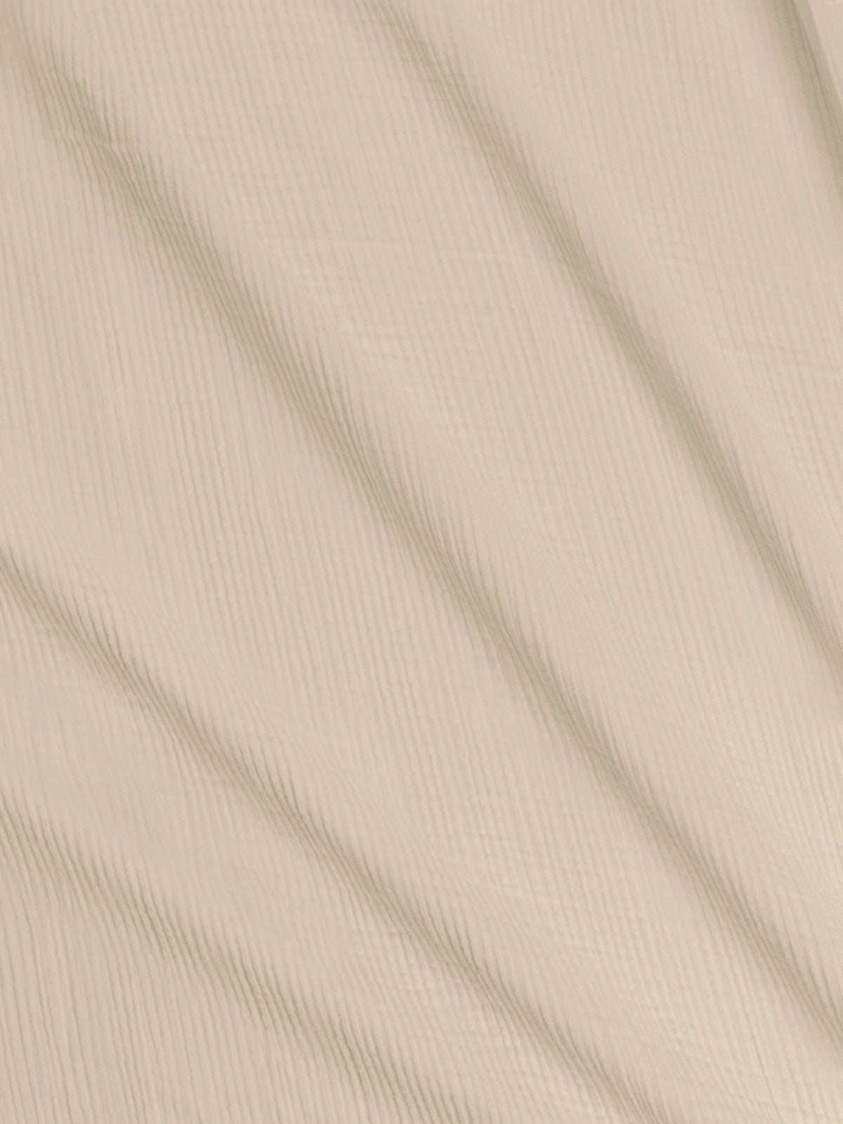 Close-up of the textured organic cotton muslin fabric in Clay.